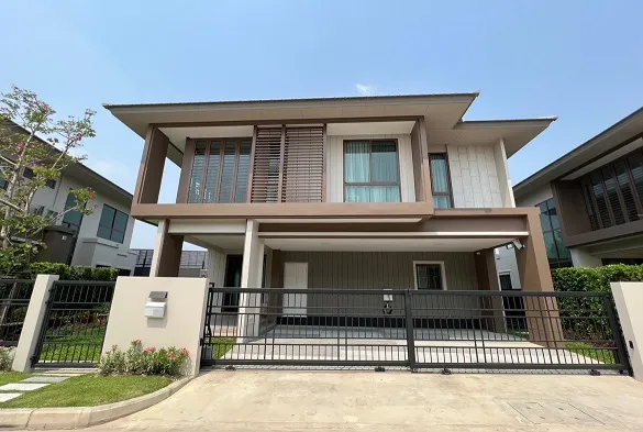 บ้านสองชั้นสไตล์โมเดิร์น หลังคาแบน หน้าต่างบานใหญ่ และทางเข้าบ้านมีรั้วกั้น