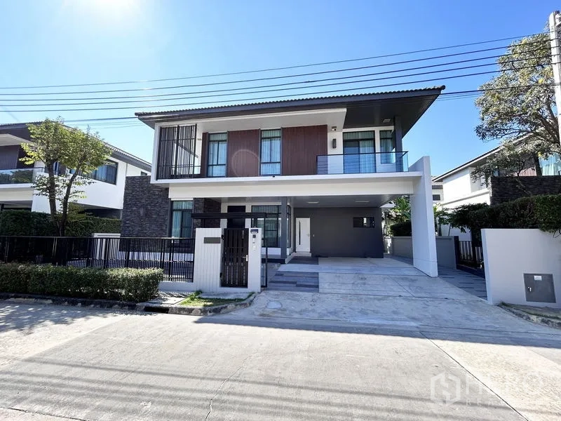 Detached House for rent or sale in Prawet, Bangkok - Modern two-storey detached house facade with balcony and carport.