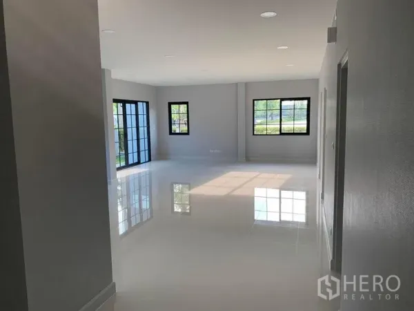 Detached House for rent or sale in Bang Phli, Samut Prakan - Bright open-plan living area with glossy white tile floors and black-framed windows