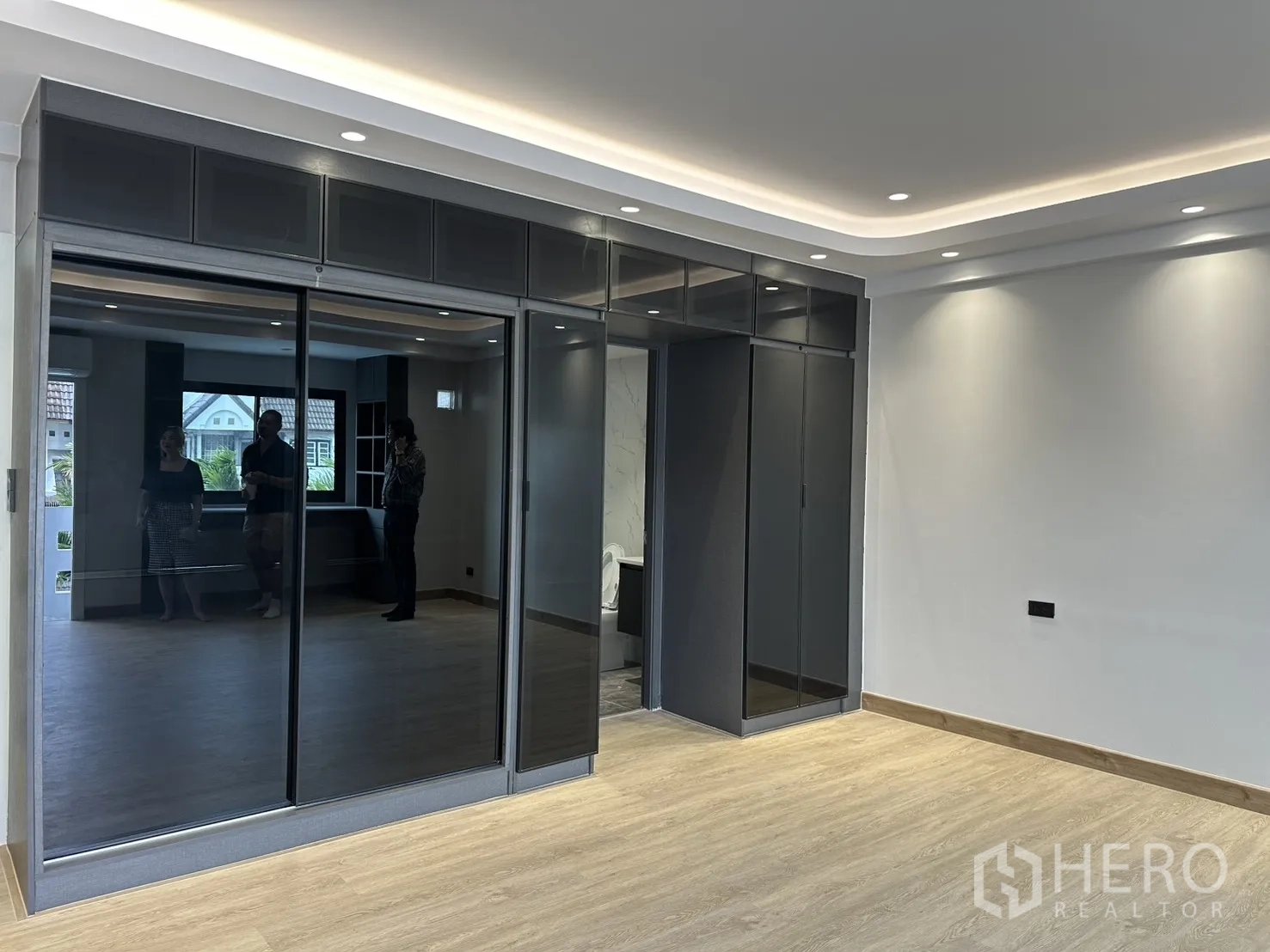 Home Office for rent in Watthana, Bangkok - Bedroom with glossy built-in wardrobes and recessed ceiling lighting.