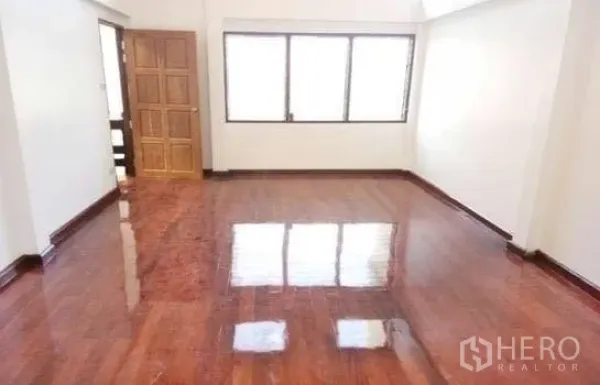 Office Space for rent in Chatuchak, Bangkok - Bright office room with glossy hardwood floors, large window and a wooden door.