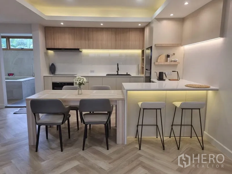Townhouse for rent or sale - Contemporary kitchen with breakfast bar, dining table and under-cabinet lighting.