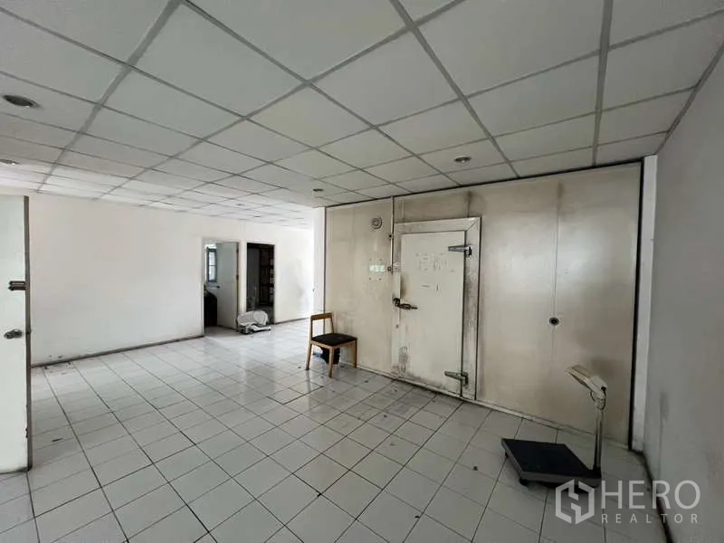 Shophouse for rent or sale in Khlong Toei, Bangkok - Open white-tiled room with a walk-in cold room door and weighing scale.