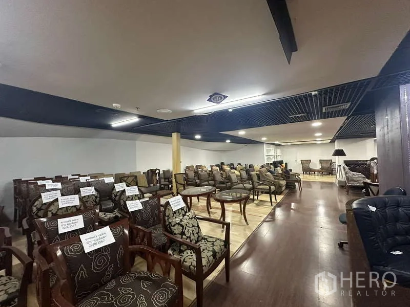 Retail Space for rent - Retail area with rows of chairs on wood floors and acoustic grid ceiling panels.