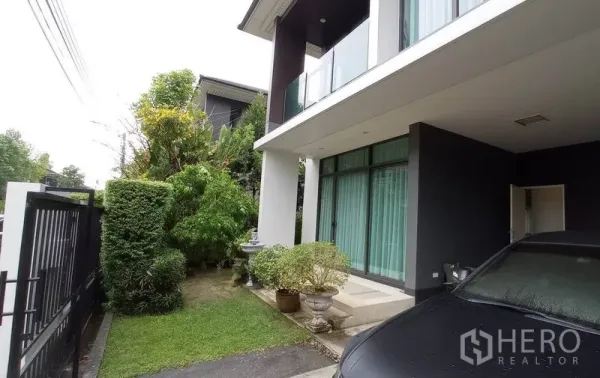 Detached House for rent in Bang Kapi, Bangkok - Side garden with lawn and shrubs beside the covered carport and front porch.