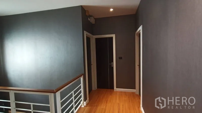 Detached House for sale in Prawet, Bangkok - Hallway and stair landing with wooden floors and white interior doors.