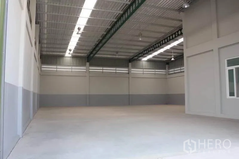 Factory for rent or sale in Lam Luk Ka, Pathum Thani - Clear-span warehouse hall with high steel roof, skylights and smooth concrete floor.