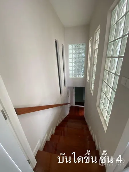 Shophouse for rent in Watthana, Bangkok - Staircase with timber steps and glass-block windows bringing light in.