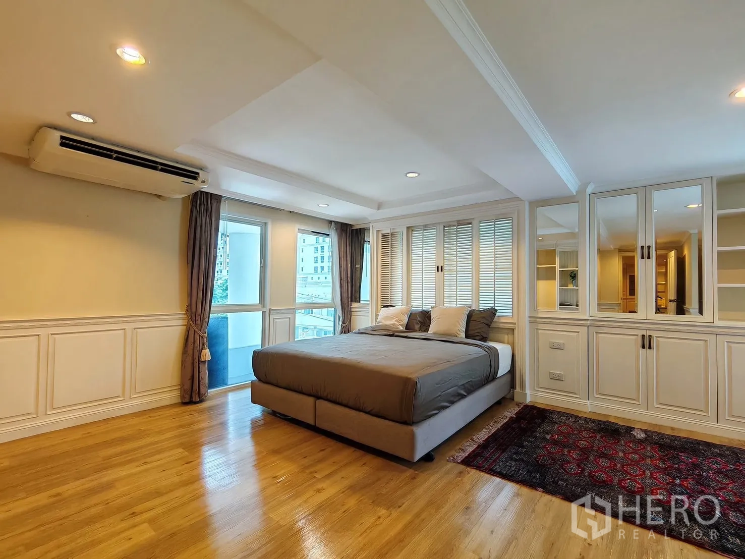 Condominium for rent in Pathum Wan, Bangkok - Master bedroom with balcony door and city outlook.