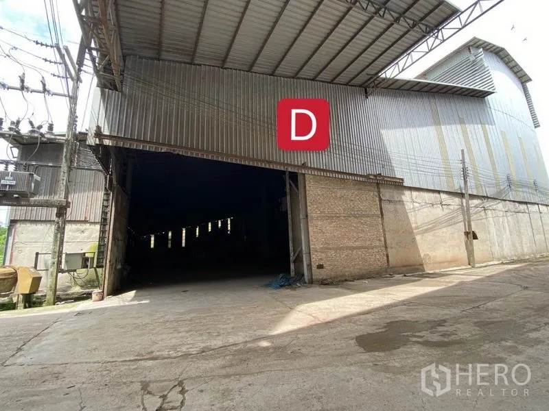 Factory for rent in Chachoengsao - Exterior of a metal-clad factory building with large gateway and street power lines.