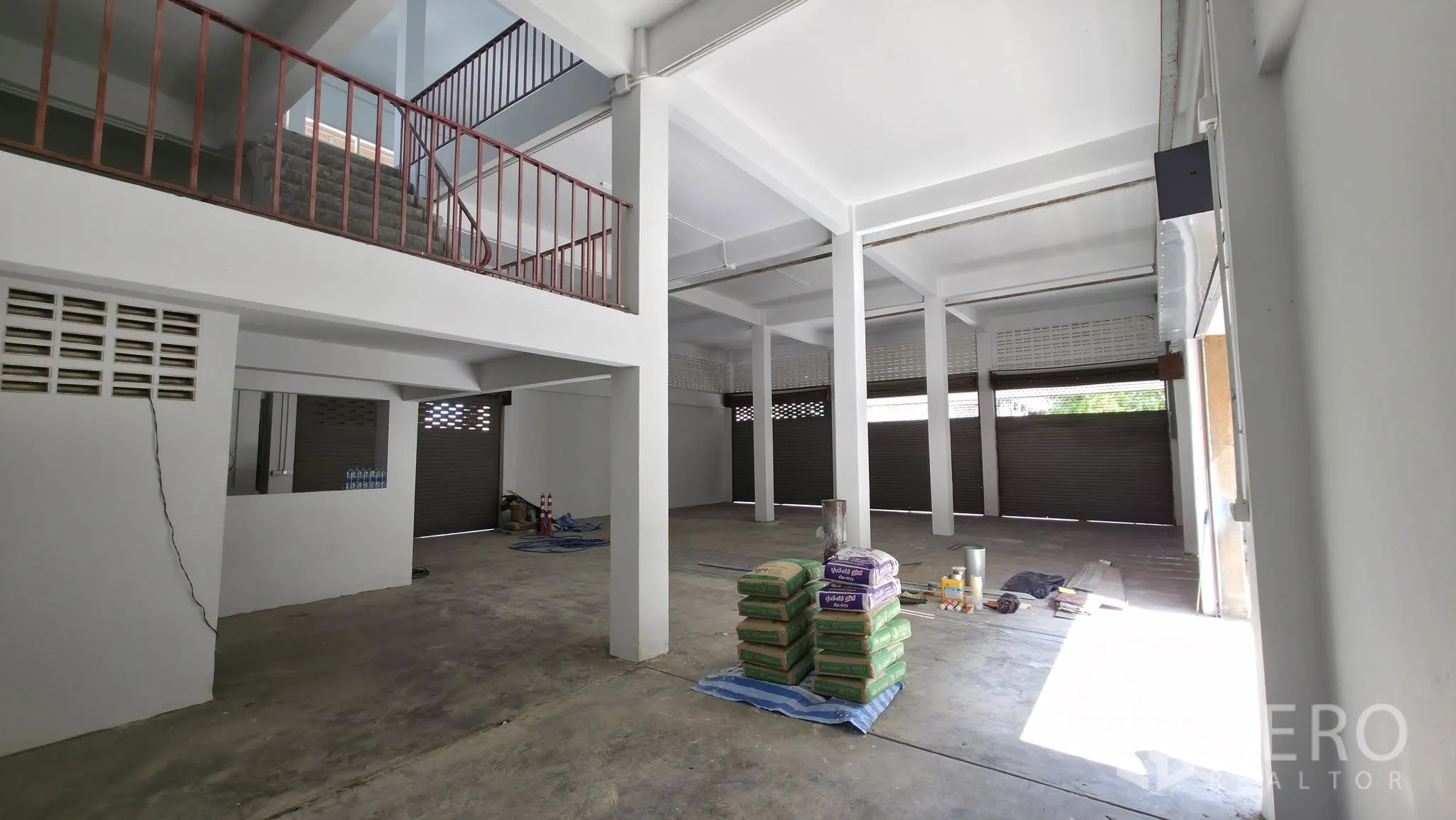 Warehouse for rent in Din Daeng, Bangkok - Ground floor space with columns and multiple roller shutter doors.