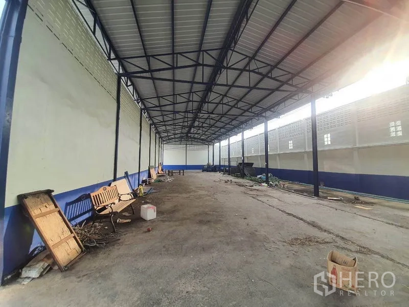 Factory for rent in Bang Bua Thong, Nonthaburi - Open-sided covered storage shed with a steel roof and concrete floor.