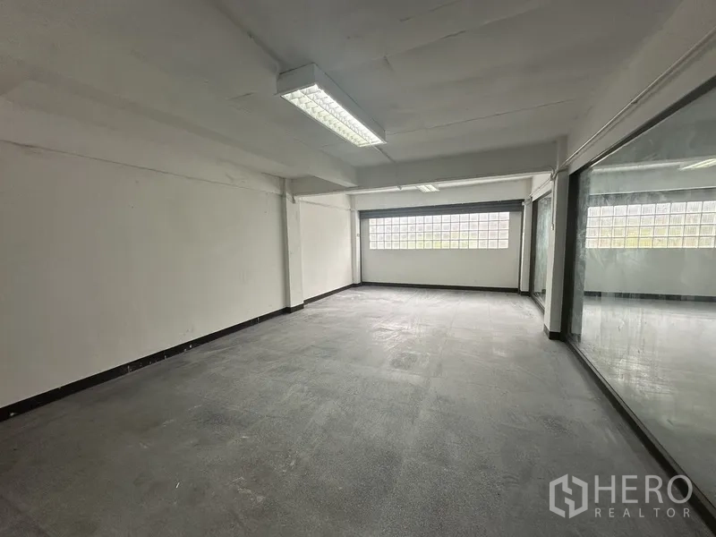 Office Space for rent in Khlong Toei, Bangkok - Enclosed office room with a large internal glass wall and glass-block window.