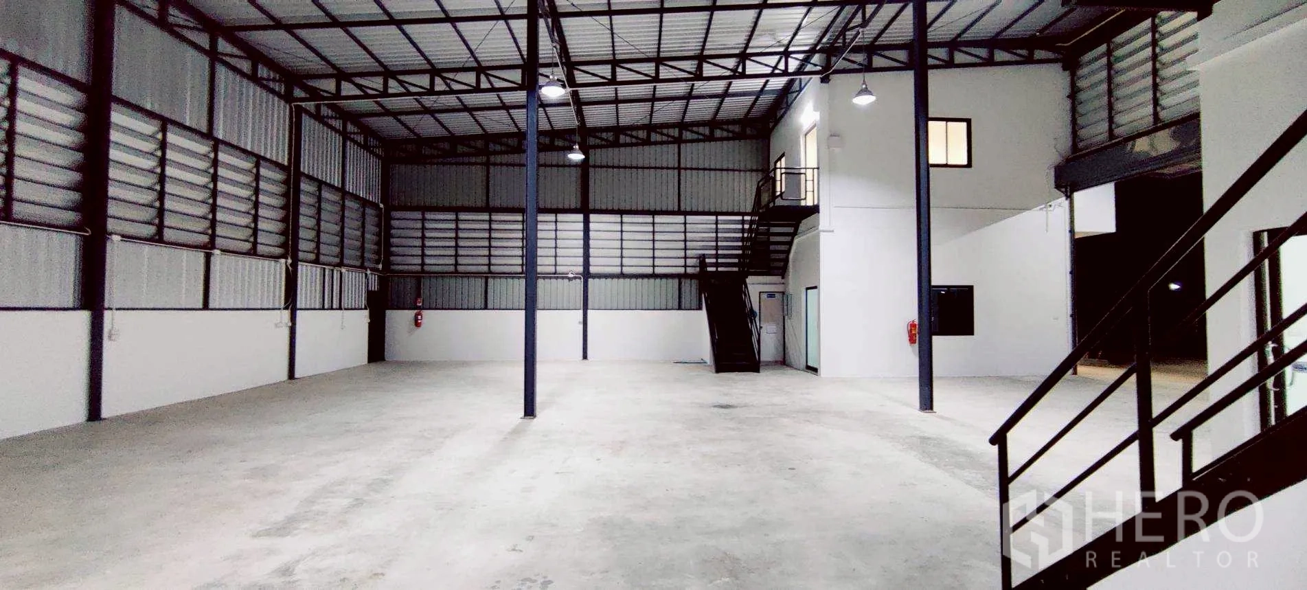 Warehouse for rent in Lam Luk Ka, Pathum Thani - Large clear‑span floor with ventilated wall panels and fire equipment.