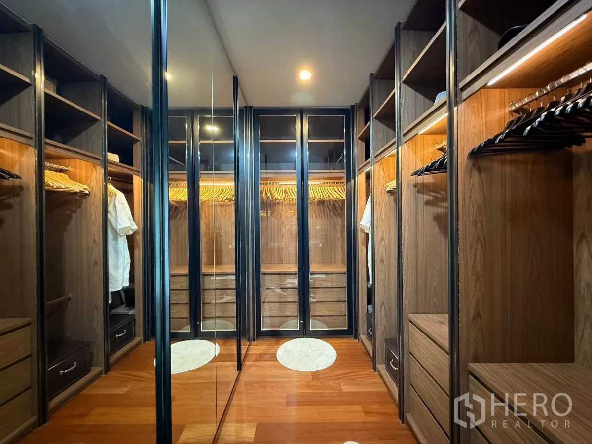 Detached House for rent or sale in Prawet, Bangkok - Walk-in closet lined with wood cabinetry and mirrored doors.
