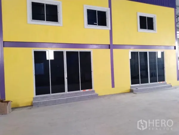 Warehouse for sale in Sai Noi, Nonthaburi - Close-up of the two-storey yellow office with sliding glass doors and windows inside the warehouse.