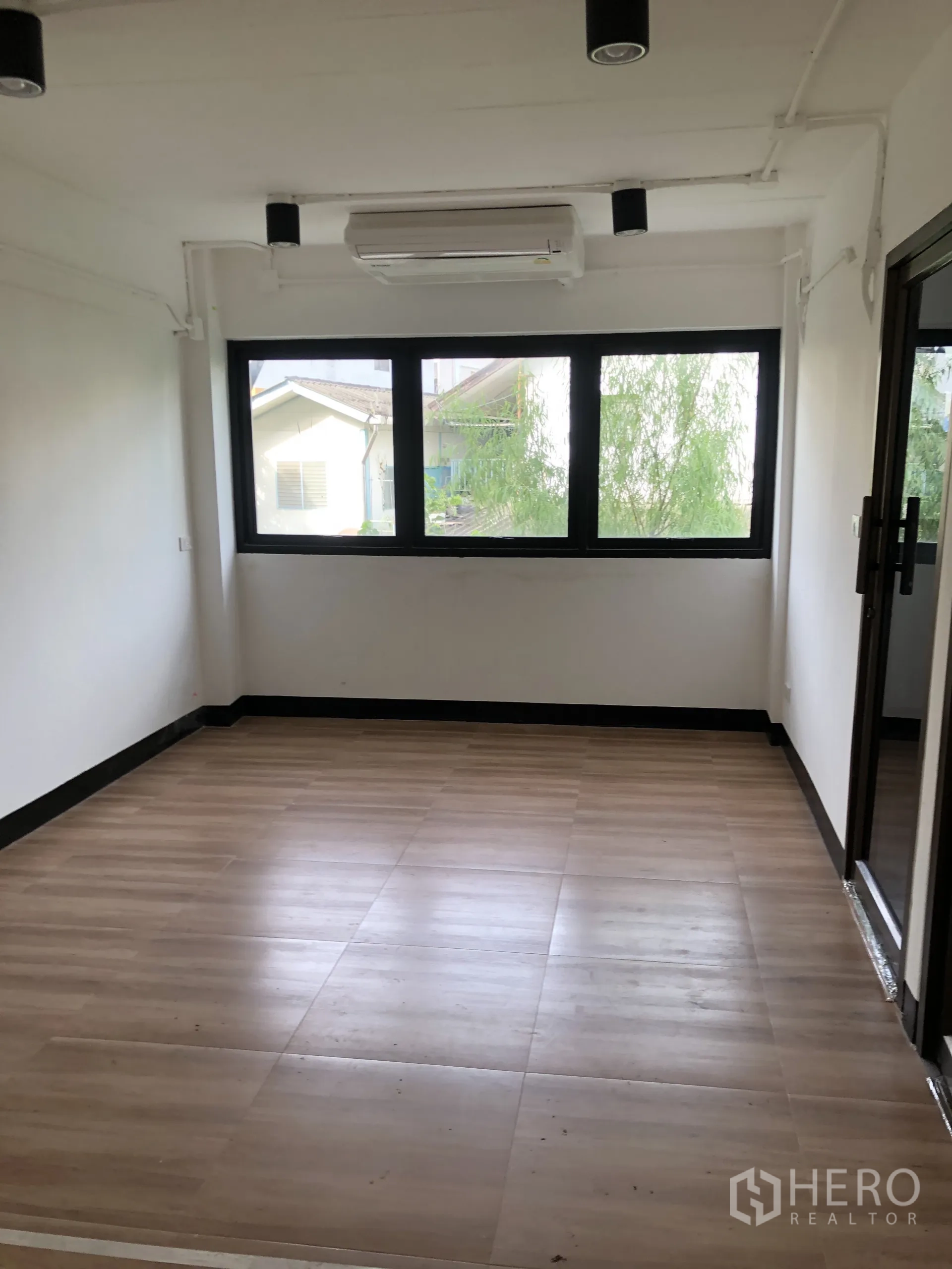 Home Office for rent in Phra Khanong, Bangkok - Private office room featuring AC and wide black-framed windows.