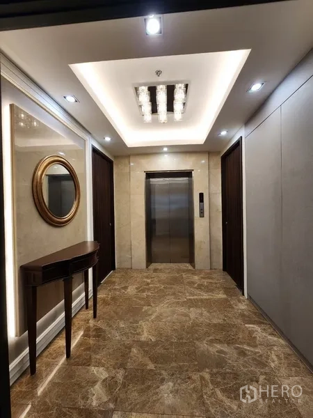 Condominium for rent in Khlong Toei, Bangkok - Elevator foyer with marble flooring and recessed ceiling lights.