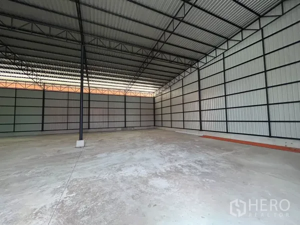 Warehouse for rent in Khlong Toei, Bangkok - Corner view of warehouse with metal sheet walls, high ceiling and clean loading surface.