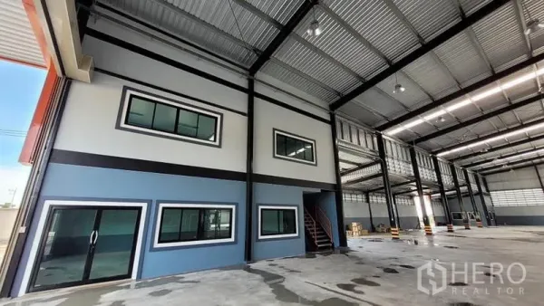 Factory for rent or sale in Phanat Nikhom, Chon Buri - Spacious factory interior showing two-level office, steel columns, skylit roof and polished concrete floor.