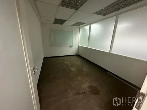 Office Space for rent in Khlong Toei, Bangkok - Meeting room with carpet, frosted interior windows and a wall‑mounted whiteboard.