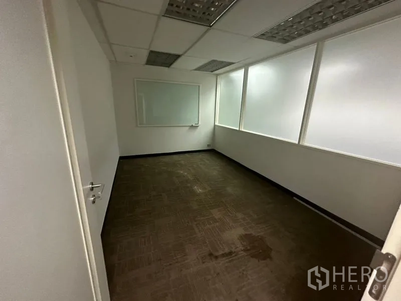 Office Space for rent in Khlong Toei, Bangkok - Meeting room with carpet, frosted interior windows and a wall‑mounted whiteboard.