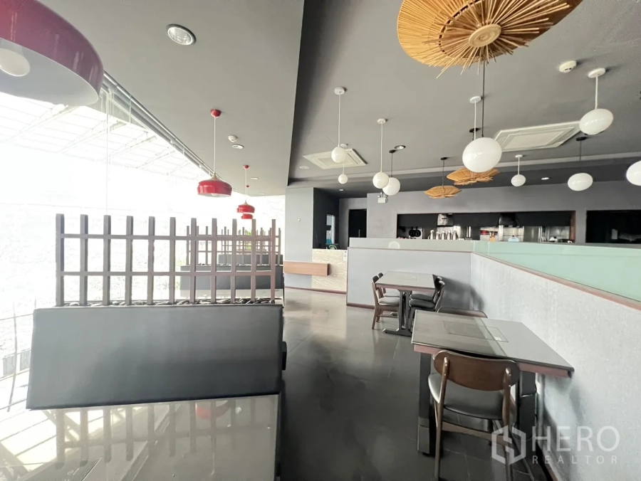 Retail Space for rent in Watthana, Bangkok - Modern retail interior with floor-to-ceiling glass, pendant lights, and dining tables ideal for a restaurant in Sukhumvit, Bangkok.