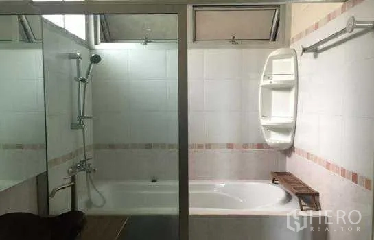 Home Office for rent in Lat Phrao, Bangkok - Bathroom with bathtub, glass-enclosed shower and wall shelving.