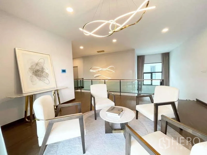 Detached House for rent in Bang Phli, Samut Prakan - Upper family lounge with four armchairs, round table, glass balustrade and pendant lights.