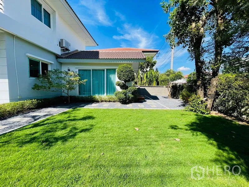 Detached House for sale in Lam Luk Ka, Pathum Thani - Wide green lawn in front of the house under a clear blue sky.