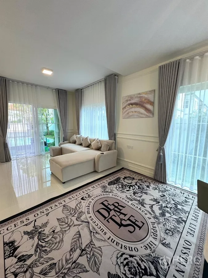 Detached House for rent in Bang Phli, Samut Prakan - Bright living room with L-shaped sofa, large windows and sheer curtains.
