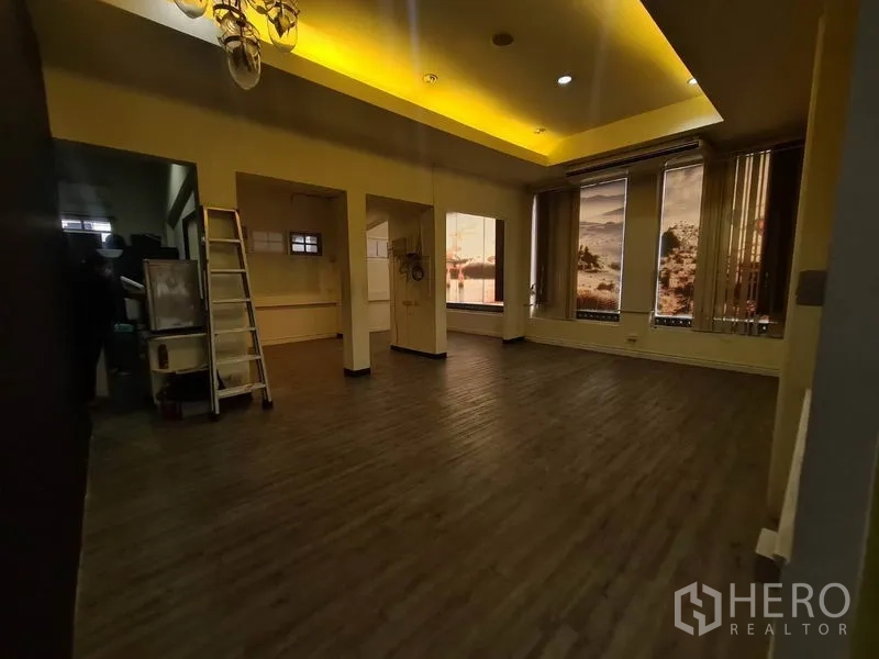 Retail Space for rent in Watthana, Bangkok - Large room with multiple tall windows, cove lighting, and dark flooring.