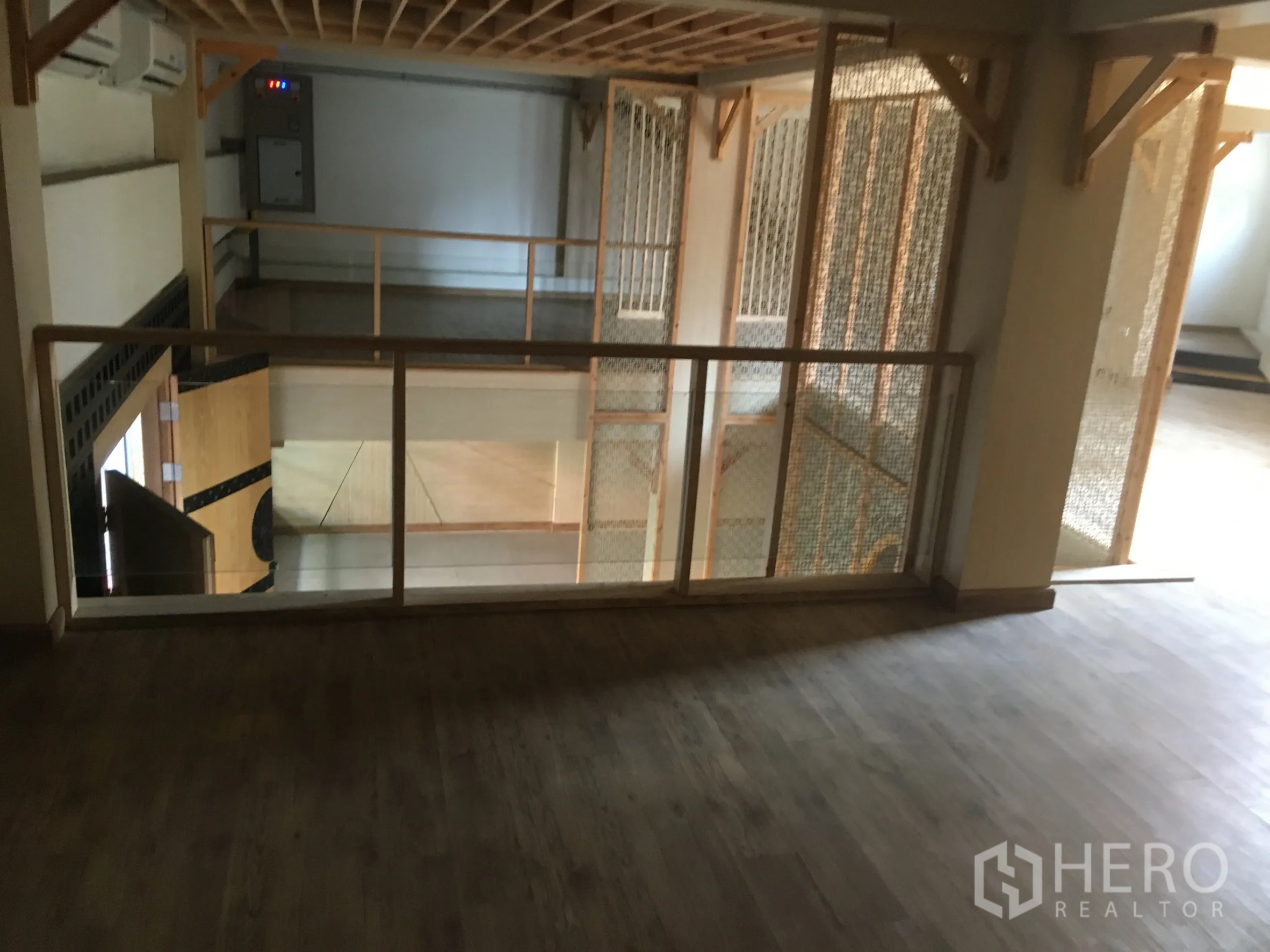 Retail Space for rent in Khlong Toei, Bangkok - Mezzanine level with wood floors and glass railing overlooking the retail area, suitable for lounge or showcase.