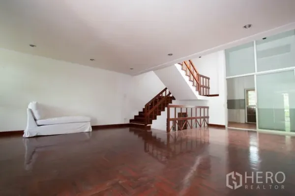 Townhouse for rent in Khlong Toei, Bangkok - Large open-plan living area showing glass sliding partition to the kitchen.