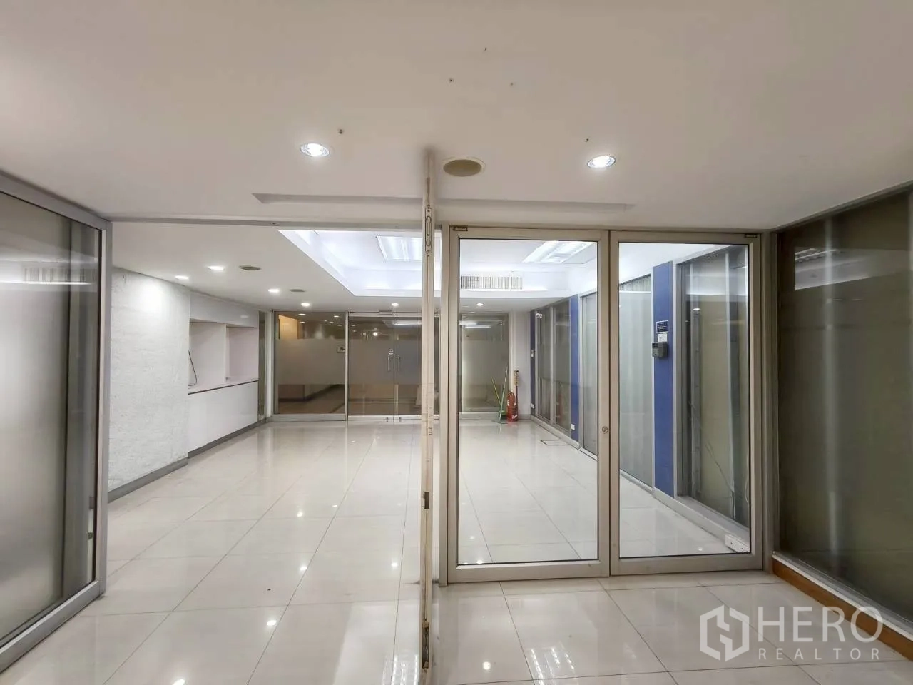 Office Space for rent in Chatuchak, Bangkok - Lobby area with glass doors, glossy tile floors and recessed ceiling lights.