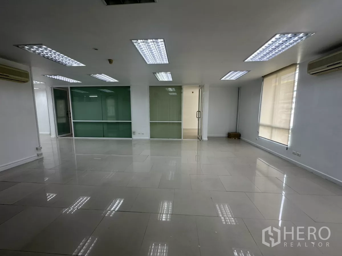 办公空间 出租在Huai Khwang, Bangkok - 开阔办公室，设卷帘大窗、天花板格栅灯与分体空调。