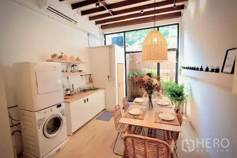 Townhouse for rent in Sathon, Bangkok - Light kitchen-dining area with beamed ceiling, washer-dryer and six-seat table