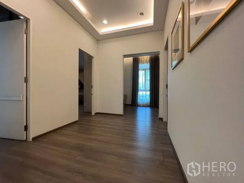 Detached House for rent or sale in Bang Phli, Samut Prakan - Upstairs hallway with recessed ceiling lights and wood laminate flooring.