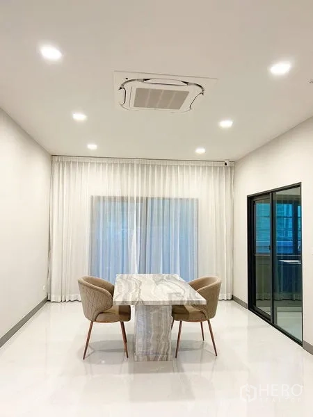 Detached House for rent in Bang Phli, Samut Prakan - Minimal dining area with marble table, chairs and full-length curtains.