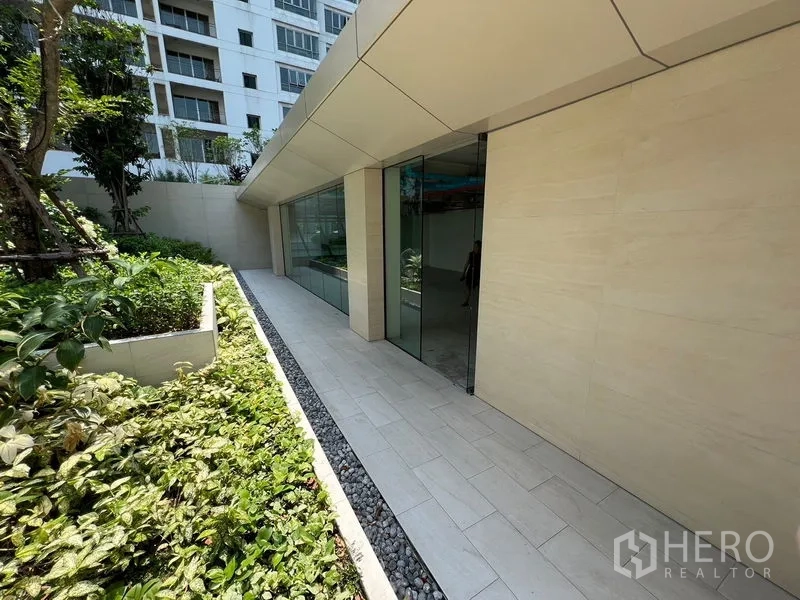 Retail Space for rent in Pathum Wan, Bangkok - Glass-fronted retail facade along a tiled walkway and planted beds.