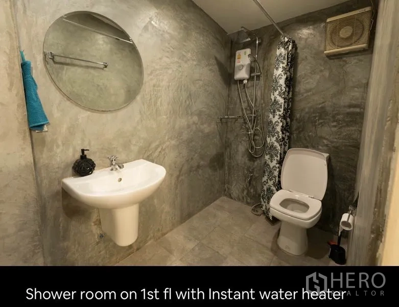 Townhouse for rent in Khlong Toei, Bangkok - First-floor bathroom with walk-in shower, instant water heater, toilet and round mirror.