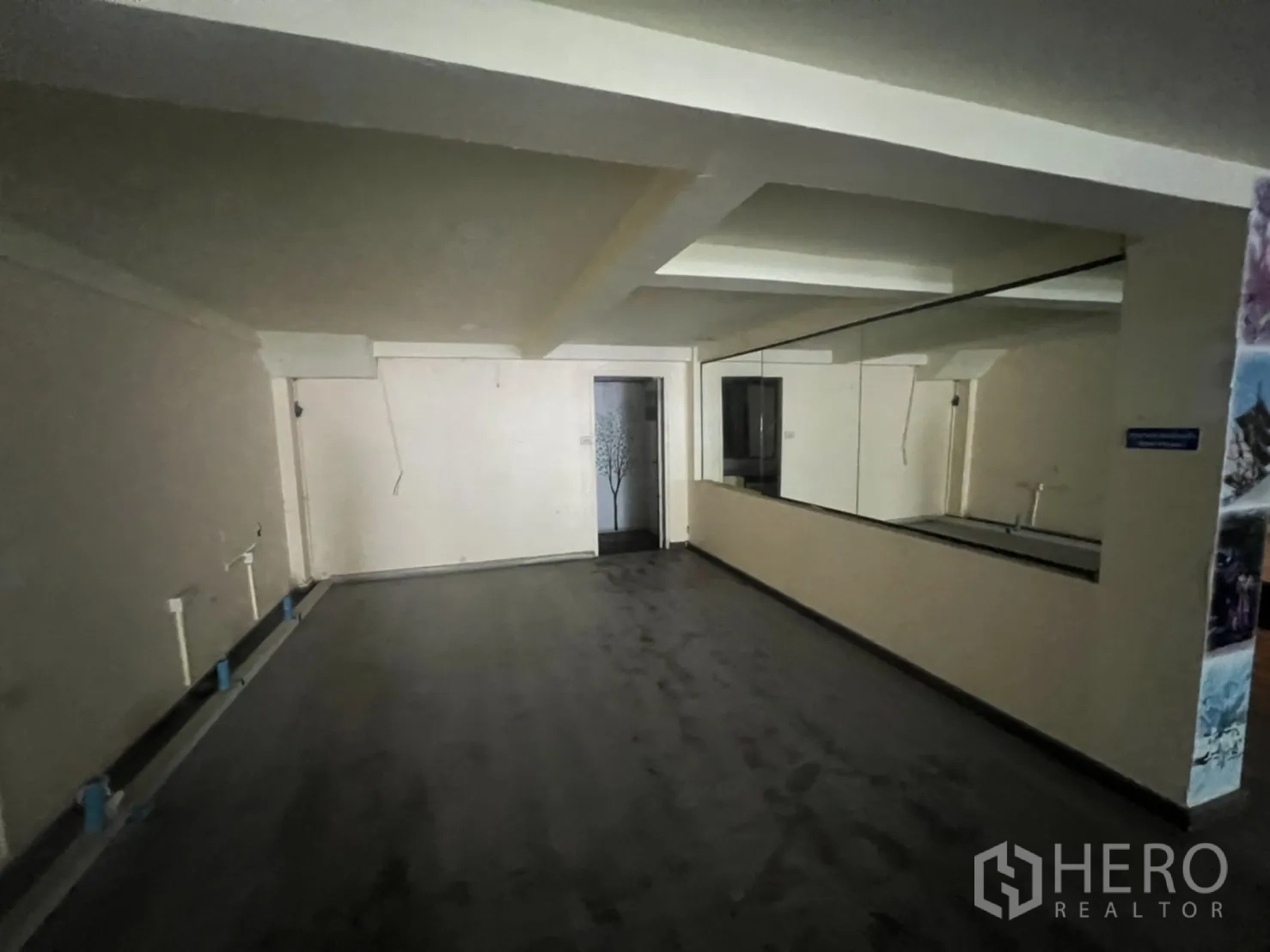 Shophouse for rent in Watthana, Bangkok - Rear ground-floor space with a long mirrored wall and plumbing points for sinks or bar.