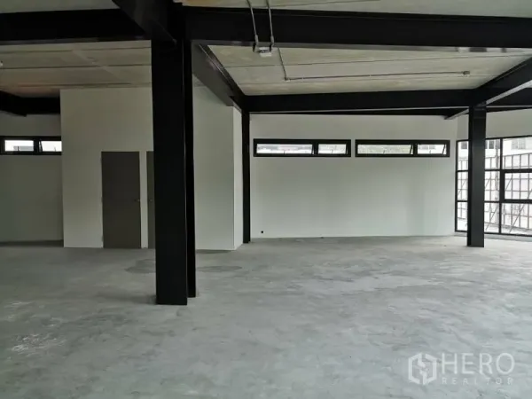 Office Space for rent in Chatuchak, Bangkok - Spacious office corner showing clerestory windows, white walls and structural steel columns.