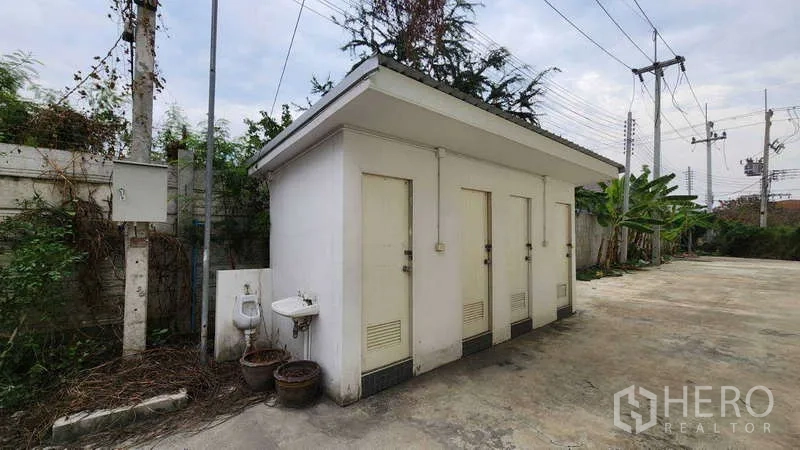 Factory for rent in Ban Phaeo, Samut Sakhon - Standalone outdoor restroom block with multiple stalls and sinks next to the factory yard.