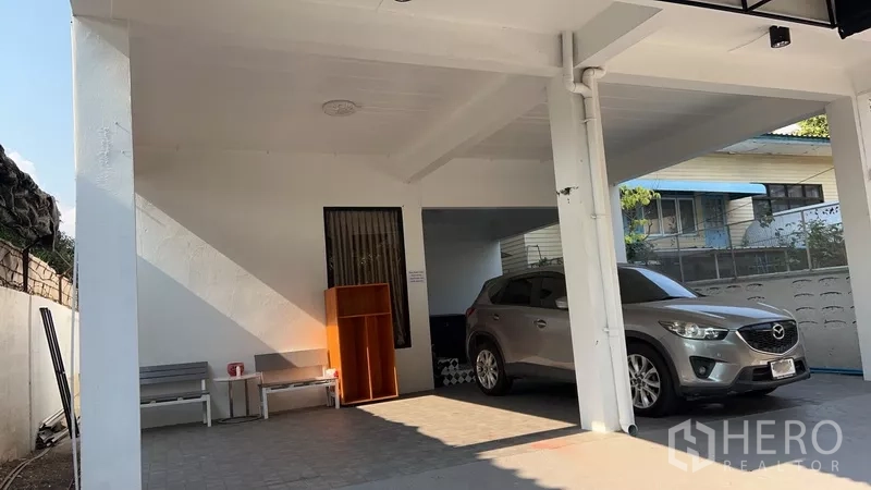 Home Office for rent or sale in Phra Khanong, Bangkok - Wide covered carport with two parking bays beside a boundary wall.