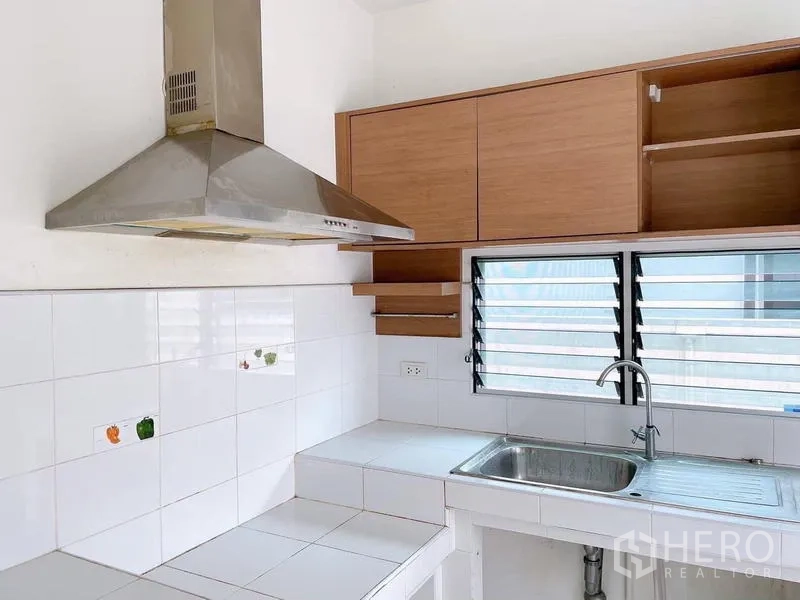 Detached House for rent in Bang Na, Bangkok - Separate Thai kitchen with range hood, sink and louvered windows.