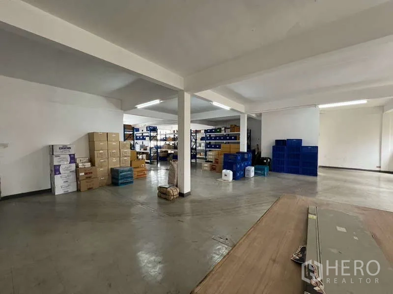 Shophouse for rent or sale in Khlong Toei, Bangkok - Open-plan upper floor used as storage with columns and fluorescent lighting.