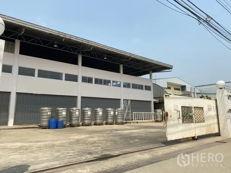 工厂 for sale in Khlong Luang, Pathum Thani - 宽阔大门与装卸场地，面向多组卷闸出入口。