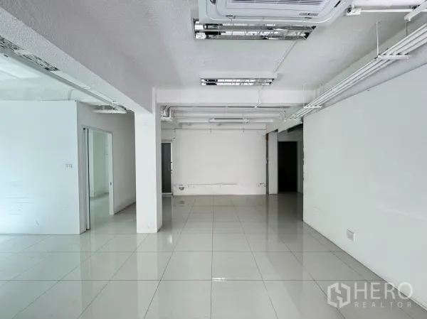 Retail Space for rent in Bang Rak, Bangkok - Spacious retail unit with columns, white walls, and a glass-partition doorway leading to back rooms.