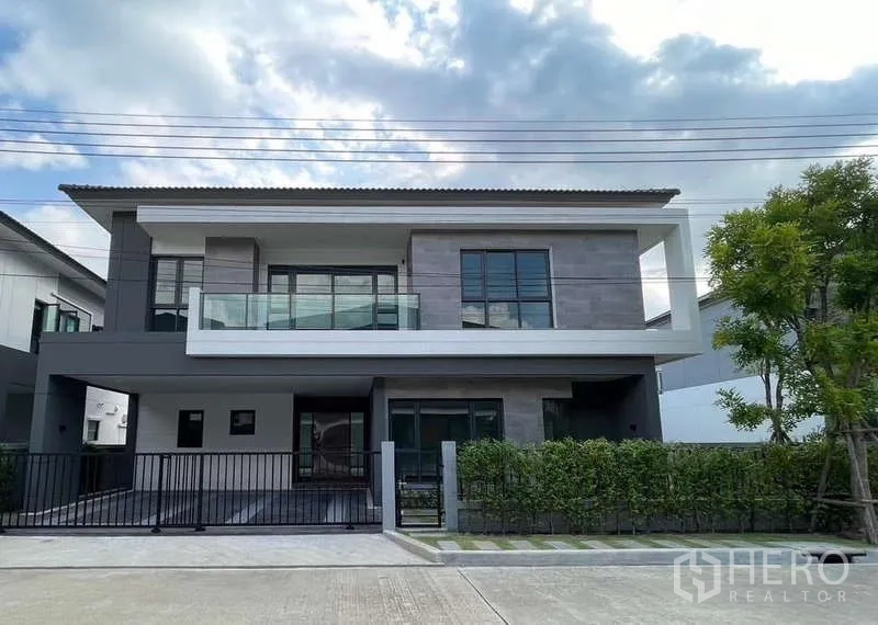 Detached House for rent in Bang Phli, Samut Prakan - Front facade of a modern two-storey detached house with glass balcony and driveway gate.